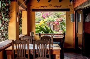 a restaurant with wooden tables and chairs and a window at La Iguana Perdida in Santa Cruz La Laguna