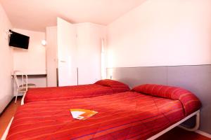 a bedroom with two beds with a red blanket at Premiere Classe Salon De Provence in Salon-de-Provence