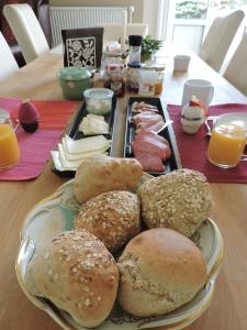 a table with a plate of buns and bread on it at Altes Pastorat in Barmstedt