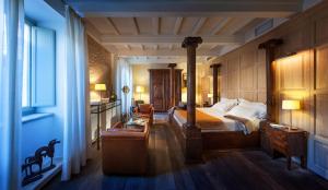 a bedroom with a bed and a desk in a room at Relais & Chateaux Palazzo Seneca in Norcia