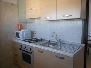 eine Küche mit einer Spüle und einer Mikrowelle in der Unterkunft B&B Grande Salento in San Marzano di San Giuseppe