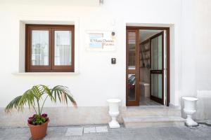 a white building with a door and a potted plant at Il Mare Dentro Rooms in San Vito lo Capo