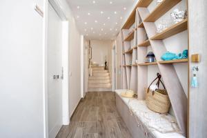 a hallway with white walls and wooden shelves at Il Mare Dentro Rooms in San Vito lo Capo