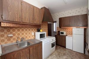 a kitchen with white appliances and wooden cabinets at chez mimoune in Trézioux
