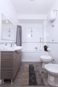 Un baño blanco con lavabo e inodoro. en Domus Citri, en Caserta 24 fotos más