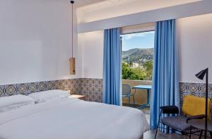 a bedroom with a bed and a window with a view at Angelina Boutique Escape in Perdika