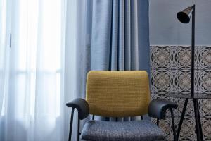 a yellow chair sitting in front of a window at Angelina Boutique Escape in Perdika