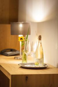 HilzingenにあるWeinvilla Vollmayerのグラス2本とボトル1本付きのテーブル