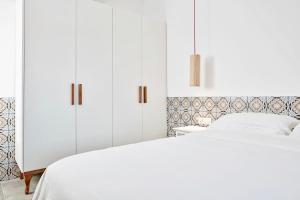 a bedroom with two beds and white cabinets at Angelina Boutique Escape in Perdika