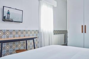 a bedroom with a bed and a table and a mirror at Angelina Boutique Escape in Perdika