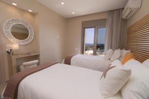une chambre d'hôtel avec deux lits et une fenêtre dans l'établissement Villa Ion Pangea Villas, à Trapezaki