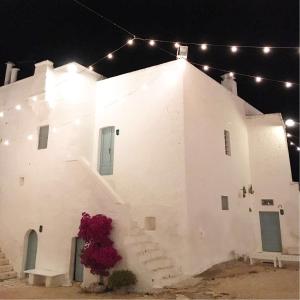 a white building with stairs and lights on it at Masseria Mozzone in Fasano