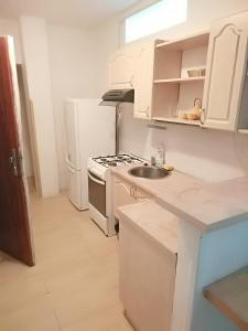 a white kitchen with a stove and a sink at Apartment Sova in Ostrava