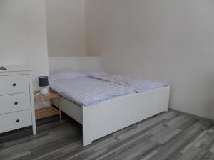 トルトノフにあるApartmány Trutnov Promenádaの白いベッドルーム(ベッド1台、ドレッサー付)