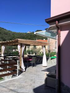 Casa vacanze La Villetta tra Cinque Terre e Versilia في أميليا: فناء مع طاولة وبيرغولا خشبي