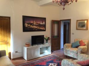 sala de estar con TV de pantalla plana en la pared en Casa vacanze Amelia, en Fiesole