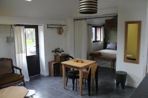 a living room with a table and a bed at L’abri du monde in Fleury-la-Forêt