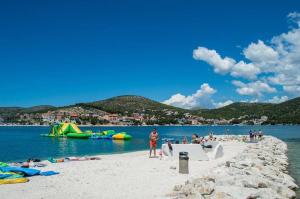 a group of people on a beach near the water at Apartments Ivana-Gustirna in Gustirna