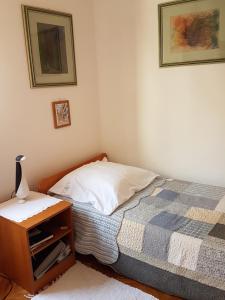 a bedroom with a bed and a table with a lamp at Apartment Slava in Primošten