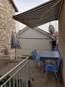 a patio with a table and chairs and an umbrella at Apartment Slava in Primošten