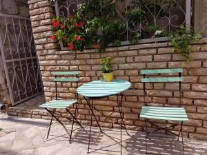 two chairs and a table with a plant on a brick wall at Apartment Slava in Primošten +4 photos