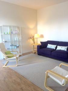 a living room with a blue couch and a table at Casa Vento dello Stagnone in Marsala