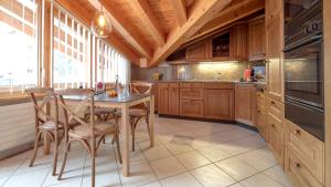 a kitchen with wooden cabinets and a table and chairs at Alpenblick Superior in Zermatt