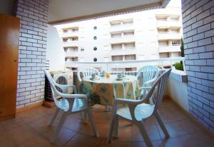 un tavolo e sedie su un balcone con tavolo e un edificio di Apartamento Trebol 2 a Oropesa del Mar