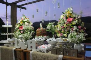 a table with trees decorated with flowers and a party sign at Ibiti Hotel Rural in Monte Alegre do Sul