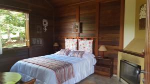 a bedroom with a bed in a room with a fireplace at Ibiti Hotel Rural in Monte Alegre do Sul