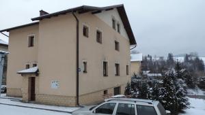 budynek z zaparkowanym przed nim samochodem w obiekcie Apartament Krystyna w mieście Tylicz