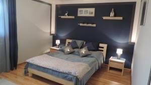 sypialnia z łóżkiem i dwoma stołami z lampkami w obiekcie Apartament Krystyna w mieście Tylicz