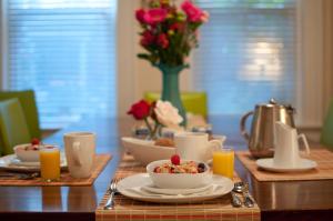 a table with a bowl of food and a vase of roses at Main Street Inn in Kansas City