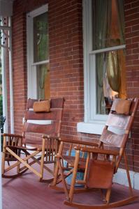 two rocking chairs sitting on the porch of a house at Main Street Inn in Kansas City