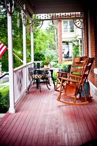 a porch with two rocking chairs and a table at Main Street Inn in Kansas City