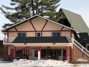 a red and white house with a black roof at Sun N Snow Hotel in Cadillac