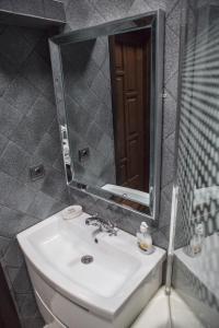 ein Bad mit einem Waschbecken und einem Spiegel in der Unterkunft Apartamenty Lwow in Lwiw