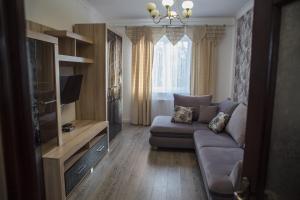 ein Wohnzimmer mit einem Sofa und einem TV in der Unterkunft Apartamenty Lwow in Lwiw