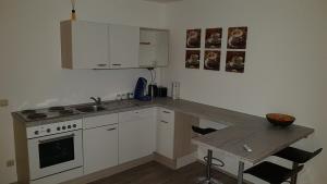 a kitchen with a counter and a sink and a stove at Ferienwohnung in Pinsdorf