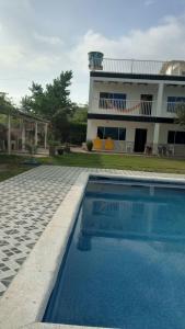 a house with a swimming pool in front of a house at Casa de Campo Palmarito in Tubará