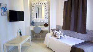 ein Wohnzimmer mit Sofa, Tisch und Spiegel in der Unterkunft Hotel Sun Holidays in Puerto de la Cruz