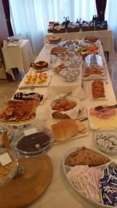 una mesa con muchos tipos diferentes de comida en ella en Hotel Gioiella Depandance, en Bellaria-Igea Marina