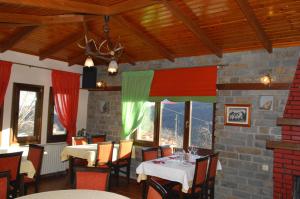 a dining room with tables and chairs and windows at Lefteris in Alatopetra