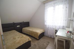 a room with two beds and a desk and a window at Chez moi in Debrecen