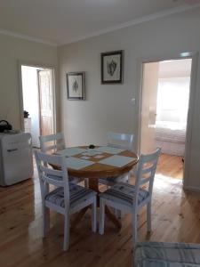 a dining room with a wooden table and chairs at Bay Bell Cottage in Saint Leonards