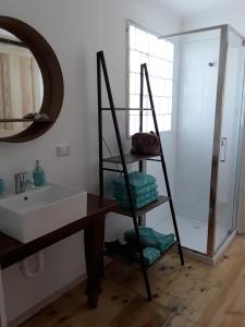 ein Badezimmer mit einer Leiter neben einem Waschbecken und einem Spiegel in der Unterkunft Bay Bell Cottage in Saint Leonards