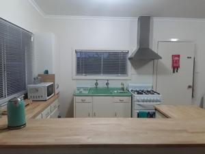a kitchen with a sink and a stove top oven at Bay Bell Cottage in Saint Leonards