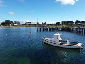 a boat sitting in the water next to a dock at Bay Bell Cottage in Saint Leonards