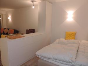 een witte kamer met een bed met een geel kussen bij Damiez (171 Zi) in Lenzerheide