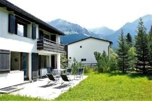 eine Gruppe von Stühlen, die vor einem Haus sitzen in der Unterkunft Ulrike (709 Sh) in Lenzerheide